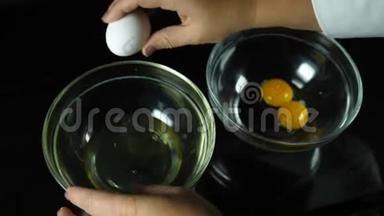 新鲜的鸡蛋掉进碗里。 蛋黄<strong>落入</strong>玻璃罐中.. 蛋黄与蛋白质的分离。 烹饪甜点