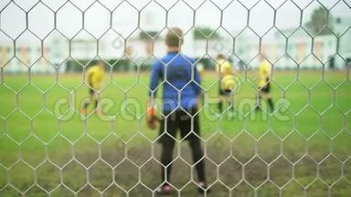 年轻男孩踢足球比赛。 穿着蓝色和黄色制服的运动员