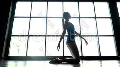 在阳光明媚的<strong>日</strong>子里，女人在窗户背景下练习<strong>瑜伽</strong>。 白人年轻女孩做<strong>瑜伽</strong>运动。 运动女孩