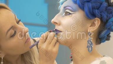 化妆师用紫色<strong>画</strong>出模特`嘴唇。 创造出神奇的<strong>形象</strong>.. 准备艺术摄影