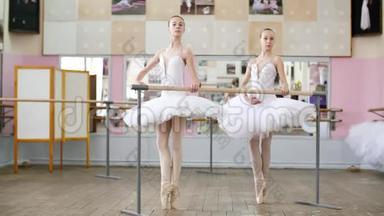 在芭蕾舞厅里，两个穿着白色芭蕾舞裙的女孩在芭蕾演出，排练PasdeBourre，Young