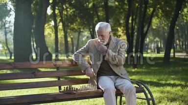 一个有思想的老人独自在公园下棋，养老金领取者的<strong>社会保障</strong>