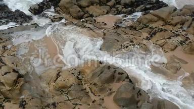 葡萄牙海滩上的砂岩岩石将空中水流回海洋
