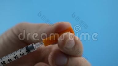 卫生工作者将疫苗注射到注射器中