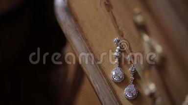 为新娘Bijouterie准备的木制旧家具装饰品上镶有钻石的结婚耳环，缎带