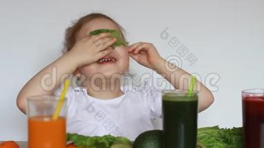 可爱的<strong>宝宝</strong>吃绿叶莴苣。 小女孩喝<strong>蔬菜</strong>冰沙-胡萝卜，甜菜和绿色。