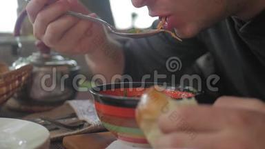 一<strong>双面</strong>目全非的手在餐馆里吃汤。 一个男人吃健康的饭，午餐。 健康的生活方式。
