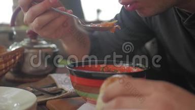 一双面目全非的手在餐馆里吃汤。 一个男人吃健康的饭，午餐。 健康的生活方式。