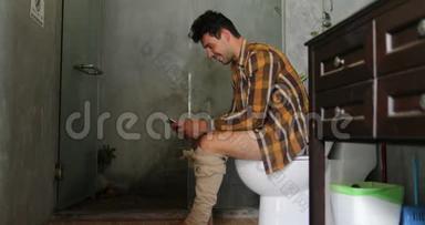 男人坐在厕所用手机年轻人上网聊天