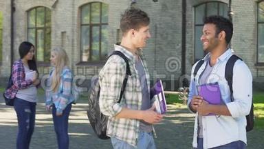 两个微笑的男学生在大学附近谈论<strong>毕业晚会</strong>