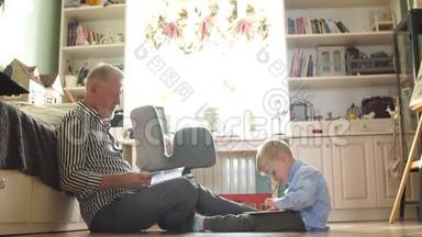 爷爷在婚礼上看相册，小男孩用电子平板电脑