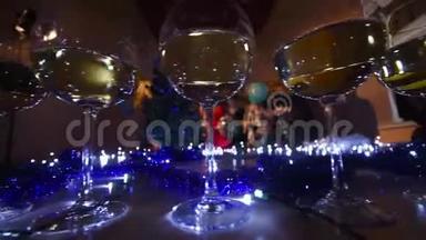 在圣诞灯光背景下的桌子上放着香槟或葡萄酒的漂<strong>亮眼</strong>镜。