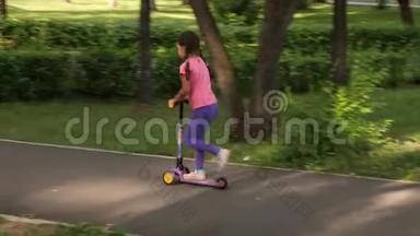 夏天，小孩子在公园里骑滑板车。 可爱的女孩在户外玩耍。 儿童休闲和户外运动