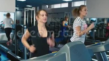 两个女人在健身房跑步机上跑步
