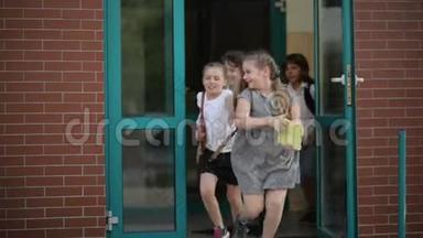 四个学生放学后玩得很开心。 他们穿校服。 学校大楼在后台。