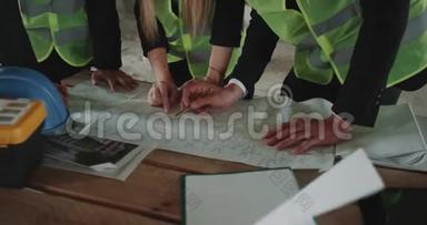 两个商人和一个女建筑师检查建筑的工作计划。