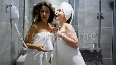 穿着白色毛巾的漂亮女人在<strong>淋浴房</strong>的背景下跳舞唱歌，梳头和淋浴头