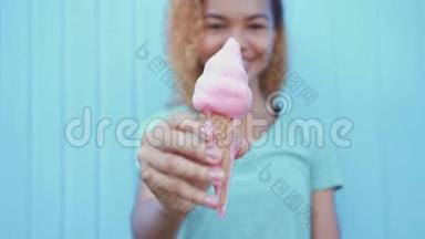 年轻的非洲女孩在蓝墙<strong>背景</strong>下吃粉色融化冰淇淋