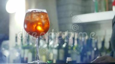 酒保在酒精饮料中加入<strong>柠檬片</strong>和塑料吸管，在酒杯特写中加入冰块，在没有聚焦的地方加入雾