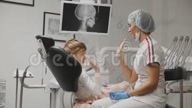 办公室牙医正畸牙医显示x光图像的牙齿，并持有建议和支<strong>架</strong>。