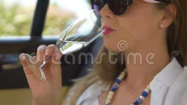 快乐的女人在豪华轿车中享受舒适，喝着<strong>清爽</strong>的葡萄酒，多莱斯维塔