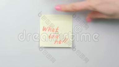 特写女人`手里贴着黄色的贴纸纸，上面写着什么鬼东西。