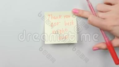 特写的女人`她的手贴着黄色的贴纸纸，上面写着感谢你度过最美好的夜晚。