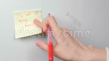 特写女人`她的手贴着黄色的贴纸纸，上面写着我`不回去的话。