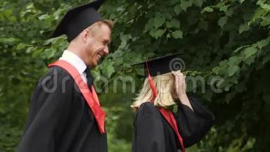 年轻的男人和女人用幸福的笑容庆祝<strong>大学毕业</strong>