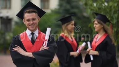 英俊的男毕业生，张开双臂为相机微笑，幸福的<strong>未来</strong>