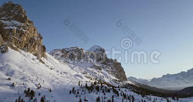 从空中飞往雪谷，森林和滑雪道在法尔扎雷戈通行证。 日落或日出，晴空<strong>万里</strong>.. 冬季