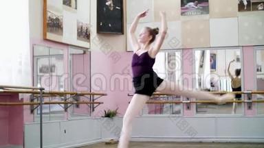 在舞厅里，穿着黑色紧身衣的年轻芭蕾舞演员表演了盛大的表演，她穿过芭蕾舞班