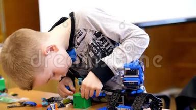 这个10岁的男孩，从立方体、盘子、电路、电线中扮演设计师。 小发明家创造机器人