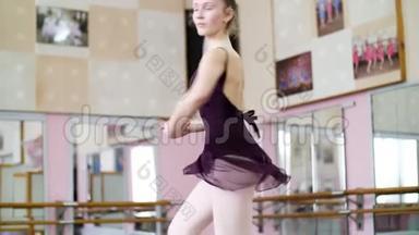 穿紫色紧身衣的年轻<strong>芭蕾舞</strong>女演员在<strong>芭蕾舞</strong>中优雅地表演某些<strong>芭蕾舞动作</strong>，以第五位的姿势表演<strong>芭蕾舞</strong>