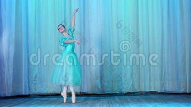 芭蕾舞排练，在老剧场大厅的舞台上.. 穿着蓝色芭蕾舞裙和尖头鞋的年轻芭蕾舞演员跳舞