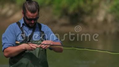 渔夫拿着一根鱼竿，在河上钓鱼，站在水里