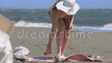 海滩上的女人用脚上的SPF<strong>防晒</strong>霜来保护皮肤免受晒伤