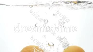 白色背景下，多汁成熟的柑橘类水果落入水中的慢镜头