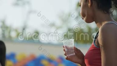 双种族女孩锻炼后饮酒，恢复水平衡，补水