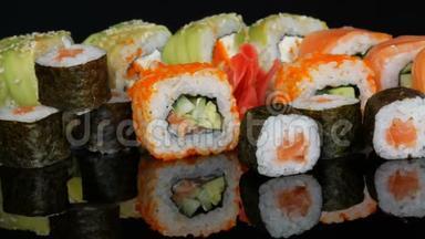 各种彩色寿司卷集和生姜在镜面上的黑色<strong>背景</strong>。 日本<strong>料理</strong>工作室