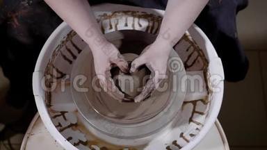 这名学生近距离拍摄了`名女子的手，试图在<strong>制作</strong>陶器的车间里<strong>制作</strong>一个陶罐