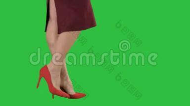 女人的腿穿着红色高跟鞋走路，商务女士穿着绿色屏幕，Chroma键。