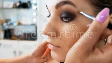 专业化妆师在工作室工作的特写慢镜头视频。 形象设计师在模特脸上化妆