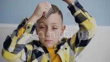 孩子正在用木梳梳理头发.. 一个蓝眼睛的男孩用梳子梳头后的特写