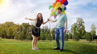 慢动作视频美丽的年轻夫妇爱玩气球和亲吻公园