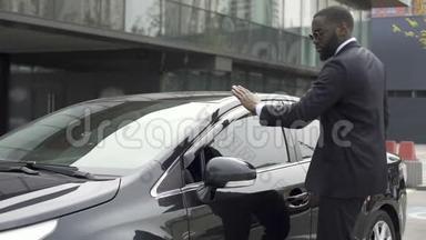 一个一丝不苟的非裔美国人在离开停车场前擦拭他的新车