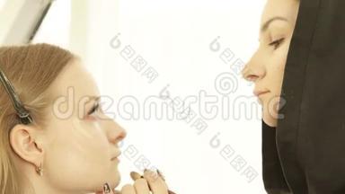 化妆师用化妆品刷在化妆室的皮肤美容模型上涂抹色调霜。 专业化妆