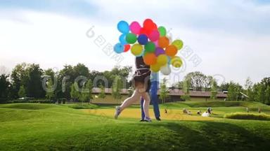 慢镜头<strong>视频</strong>快乐欢笑年轻夫妇举着五颜六色的<strong>气球</strong>在公园跳舞