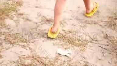 孩子们`沙滩上穿着橡胶拖鞋的腿。