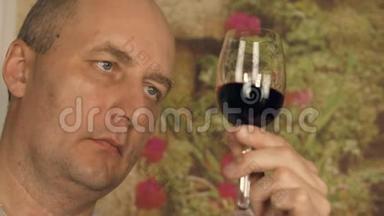 成年男士侍酒师在近距离品尝红酒之前，先用杯子看红酒